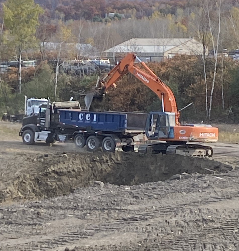 Orange Excavator Dumping Sand in a Truck